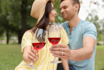 Happy young couple having picnic in park on summer day