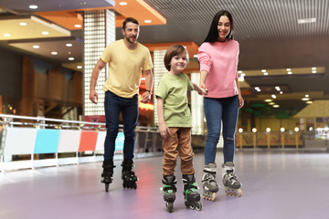 Happy family spending time at roller skating rink