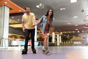 Young couple spending time at roller skating rink