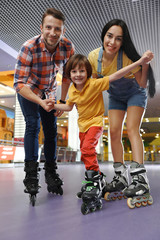 Happy family spending time at roller skating rink