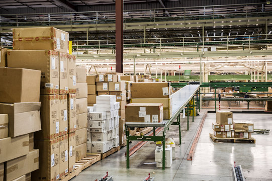 Cardboard boxes on conveyor belt in warehouse