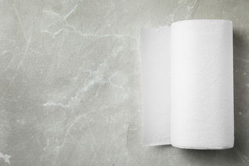 Roll of paper towels on grey stone table, top view. Space for text