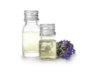 Bottles with natural lavender oil and flowers on white background