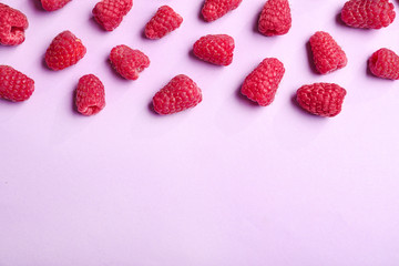 Tasty ripe juicy raspberries on pink background, top view with space for text