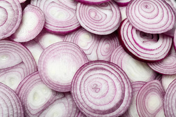 Cut fresh red onions as background, top view