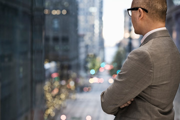 Businessman looking through window in office