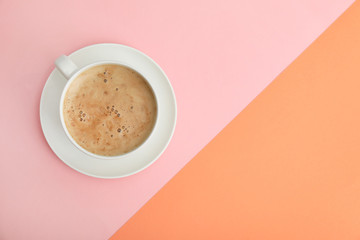 Cup of coffee on color background, top view. Space for text