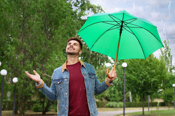 Man with umbrella outdoors on rainy day