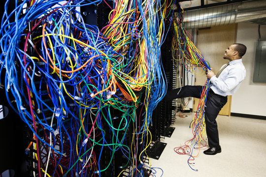 Frustrated technician pulling cat 5 cables in server room