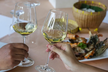 A chin-chin with white wine glasses over a restaurant table
