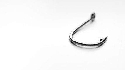 Fishing hook on white background, shallow depth of field