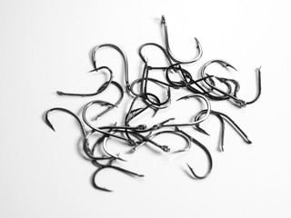 Fishing hooks on white background, top down.