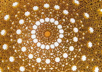 Watching the sky through the intricate patterns of golden gazebo dome in Muscat, Oman.