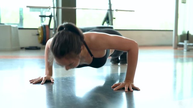 Professional beautiful asian woman workout doing push up exercise in the fitness gym healthy lifestyle, athlete muscle building strong and fit body 4k resolution. 