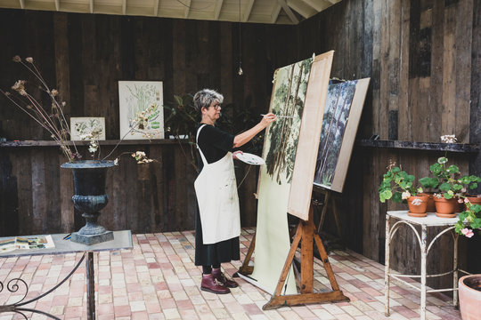 Side view of artist painting in studio