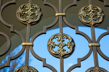 Detailed view of the decorated patterned cast iron fence. Fence grating with sharp peaks. The...