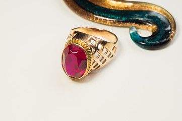 Golden ring with ruby on white background