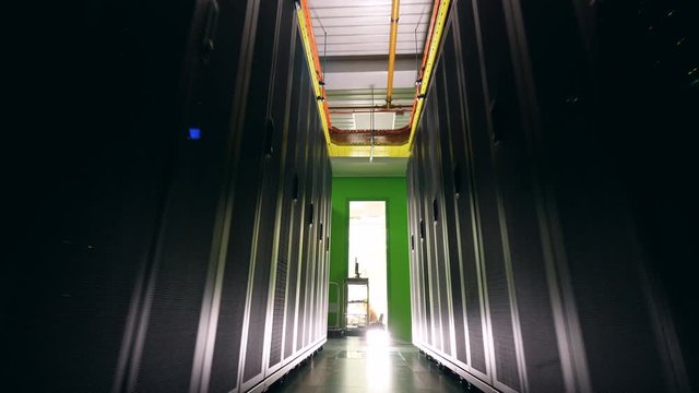 Black server blocks with a pathway between them. Data center, data security, data ptotection, data magement, data storage, server room, server rack, server farm.
