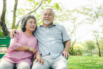 Naklejka premium Happy elderly couple with lifestyle after retiree concept. Lovely asian seniors couple embracing together in the park in the morning.