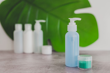 Fototapeta na wymiar organic lotion isolated from a group of other skincare products with tropical leaf in the background
