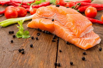 Raw salmon fillets and ingredients for cooking on old wooden floors