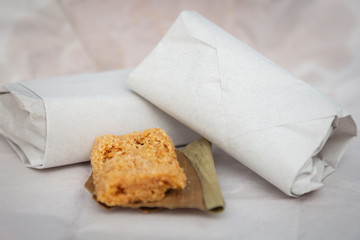 Crushed nuts, wrapped in paper and placed on banana leaves