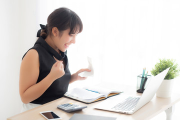 Beautiful young asian woman calculating finance household and writing notebook on desk, girl checking bill and success for saving expenses household with target, debt closure, business concept.