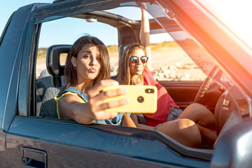 beautiful girls and young people traveling with the jeep car