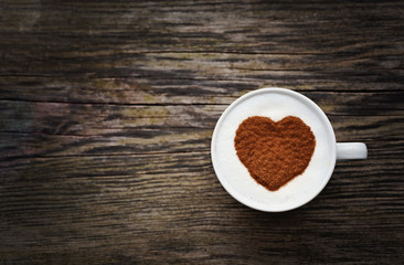 Obraz na płótnie Canvas Cinnamon heart in a coffee cup on a wooden background