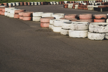 Race track safety barrier. asphalt racing track with red and white tires. colorful tires stack. karting racetrack