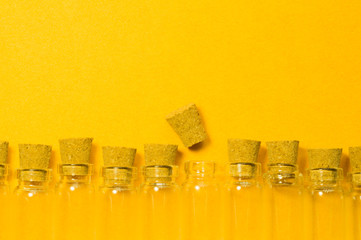 Empty little bottles with cork stopper isolated on yellow. transparent containers. test tubes