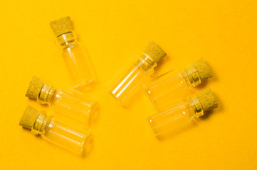 Empty little bottles with cork stopper isolated on yellow. transparent containers. test tubes