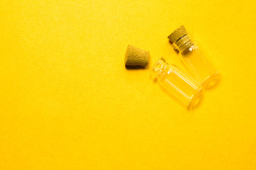 Empty little bottles with cork stopper isolated on yellow. transparent containers. test tubes. copy space