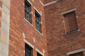 Fototapeta na wymiar Old red brick wall with windows background