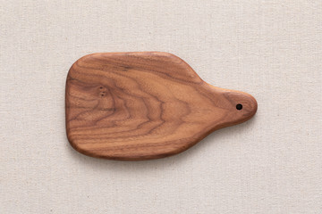 Walnut handmade wood cutting board on the linen	