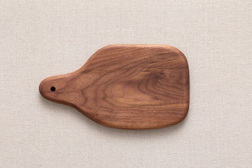 Walnut handmade wood cutting board on the linen	
