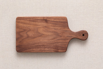 Walnut handmade wood cutting board on the linen