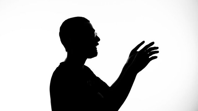 Silhouette of a man explaining something making gestures