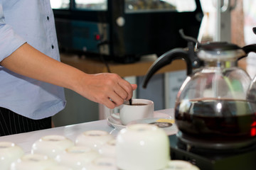 female hand stiring cup of coffee