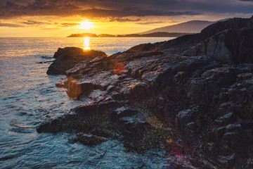 Stunning lighthouse sunsets on a rocky beach with mountains surrounding.  Bowen Island BC Canada.  Close to downtown Vancouver.