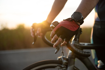 Hands in gloves holding road bicycle handlebar. Sports and outdoor activities concept.