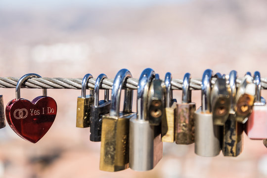 A lovely red heart shaped lock whith a writing of "Yes I Do"