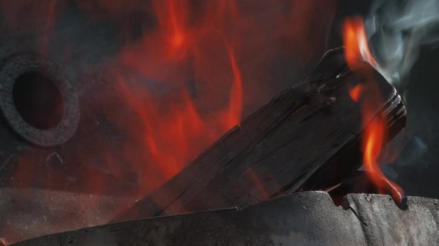 Wooden logs burning for coals in brazier grill. Burning wood. Burning grill. Close up shot.