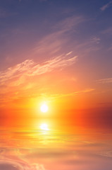 Beautiful orange sea sunset with bright sun and clouds.