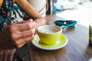 Woman drinking cappuccino in a coffee shop.