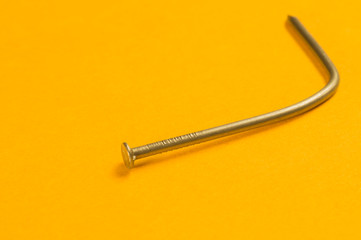 Steel screw on a yellow background