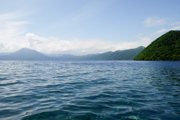 Fototapeta premium Mountain lake view in good weather morning time on blue clouds sky background.