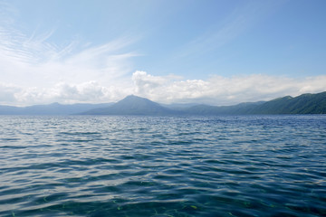 Mountain lake view in good weather morning time on blue clouds sky background.
