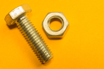 Screws on a yellow background. pile of fasteners