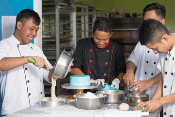Fototapeta na wymiar team of pastry chef inside kitchen